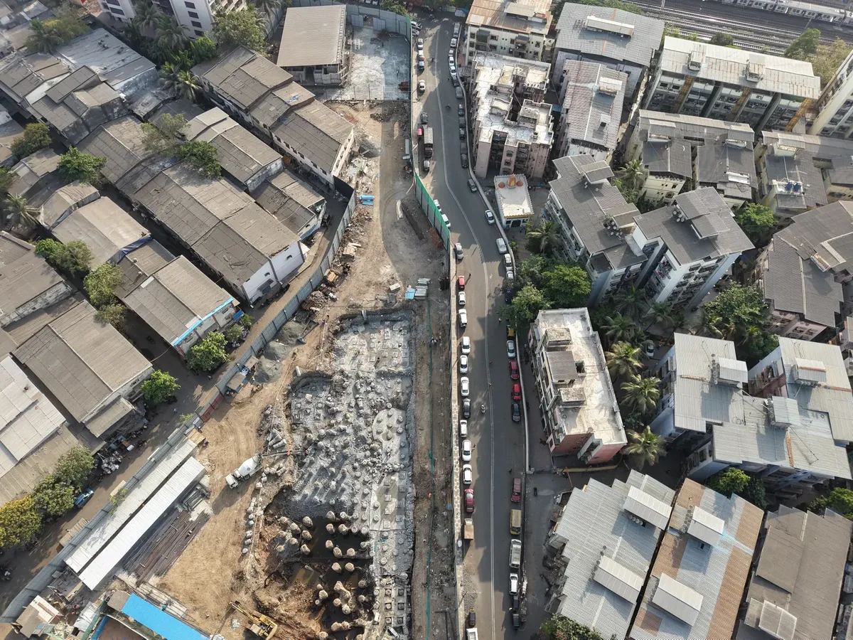 Aerial view of construction site amidst dense urban architecture in Mumbai, India.