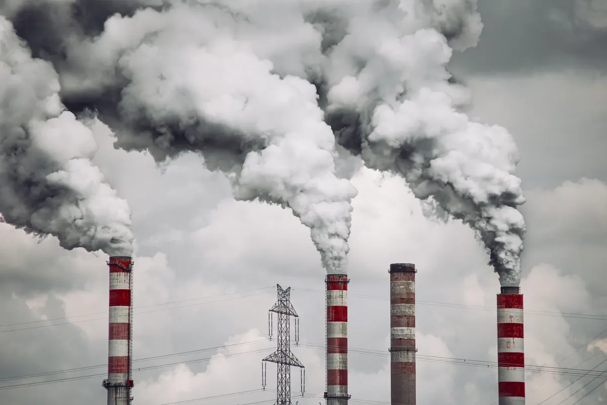 Smoke billows from factory chimneys in Konin, Poland, highlighting pollution and environmental impact.
