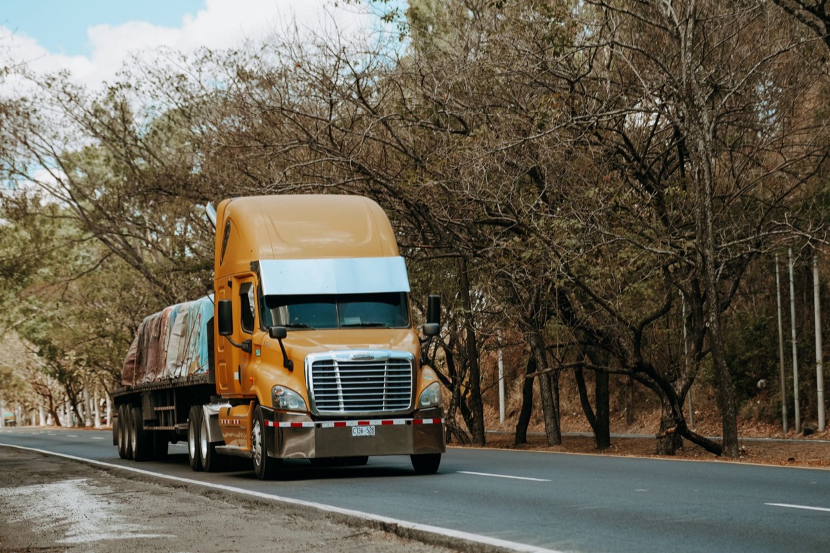 Heavy-duty truck emitting black smoke, highway environment