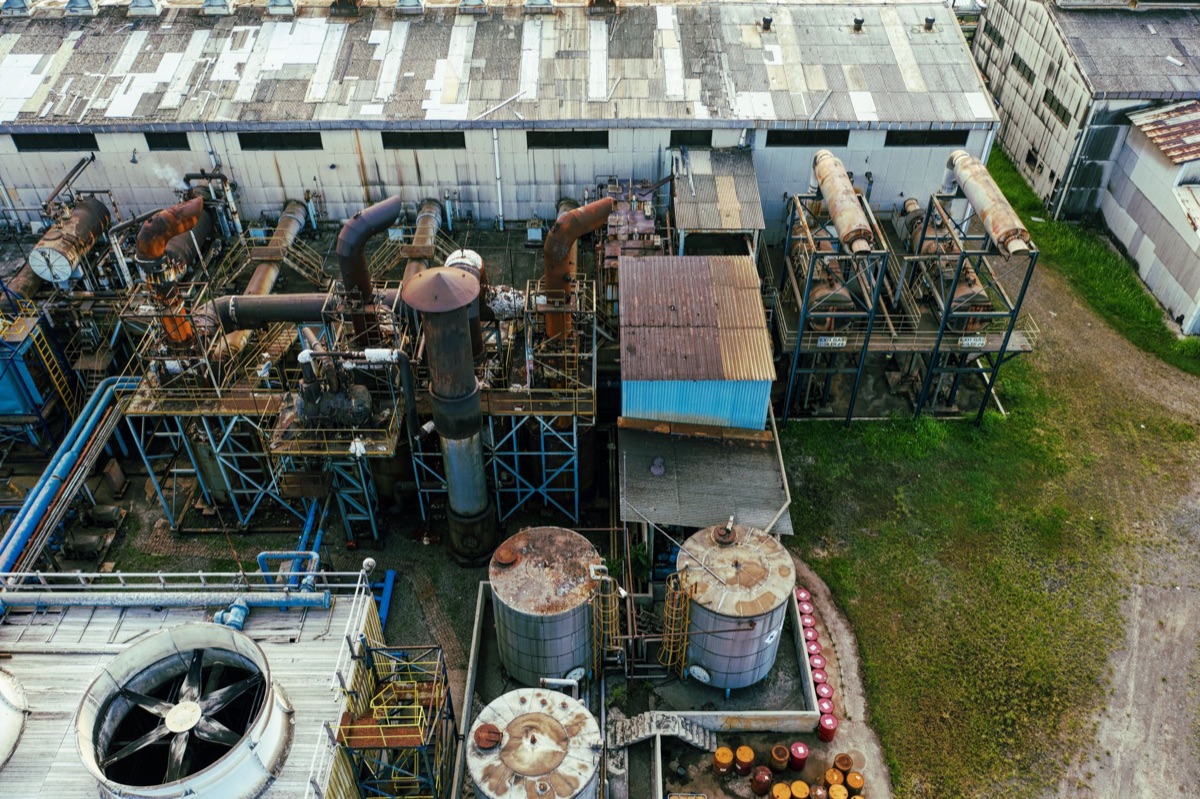 Fábrica industrial com máquinas pesadas, poluição no ar