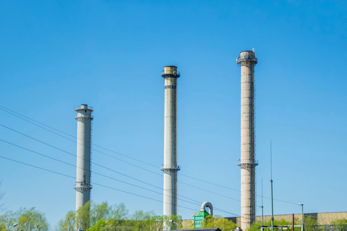 chimenea industrial con humo y nubes